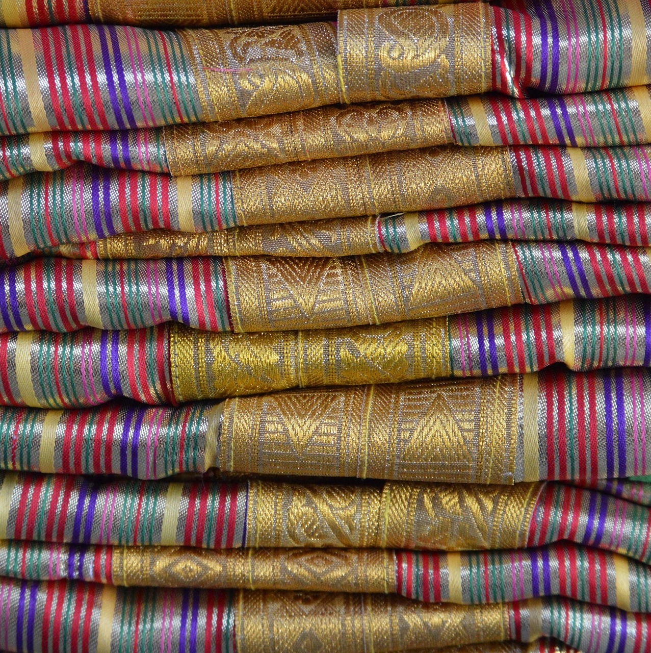 Vibrant display of Moroccan textiles in Marrakech Souks, showcasing a rich array of colors, patterns, and traditional weaving techniques