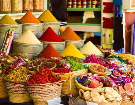 Assortment of Moroccan culinary treasures in Marrakech Souks, featuring spices, traditional sweets, and local delicacies